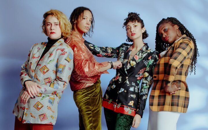 The 4 female members of Kalbells dressed in powersuits of plaid for their new album, Max Heart